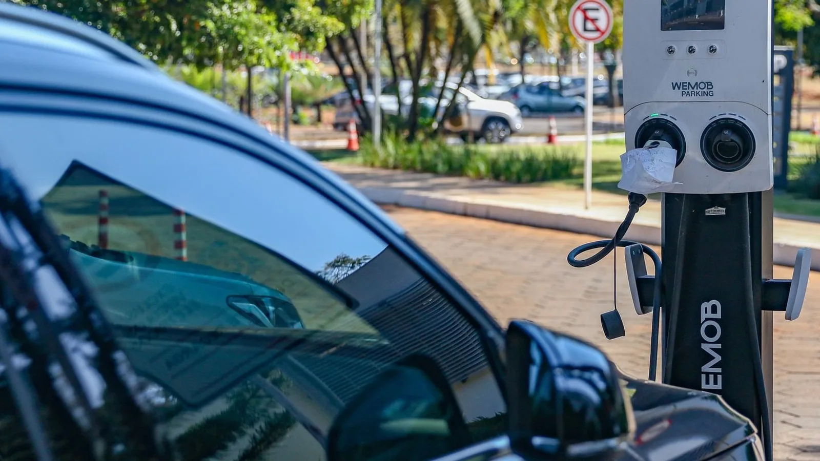 Carro elétrico conectado a um ponto de recarga em um estacionamento de Brasília
