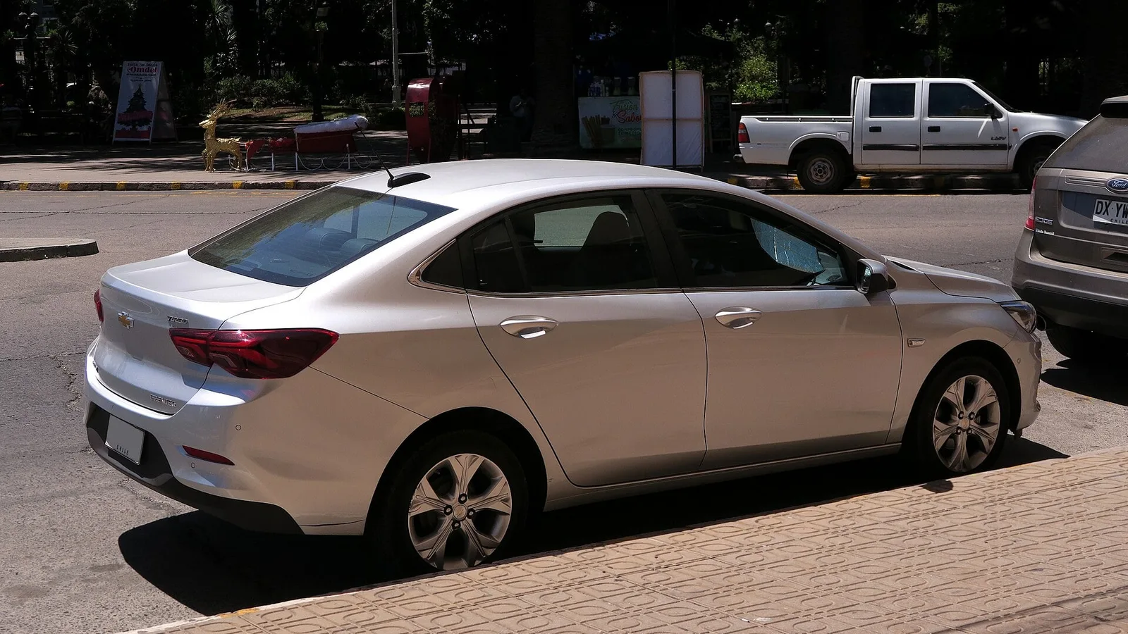 Sedã Chevrolet Onix prata de quatro portas estacionado na rua