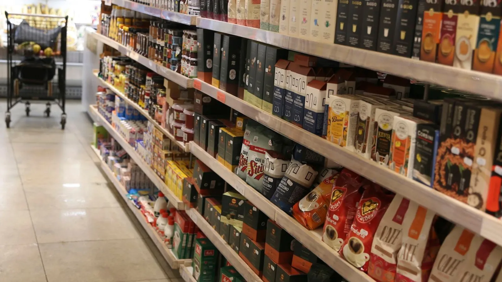 Prateleiras de supermercado abastecidas com pacotes de café e outros produtos