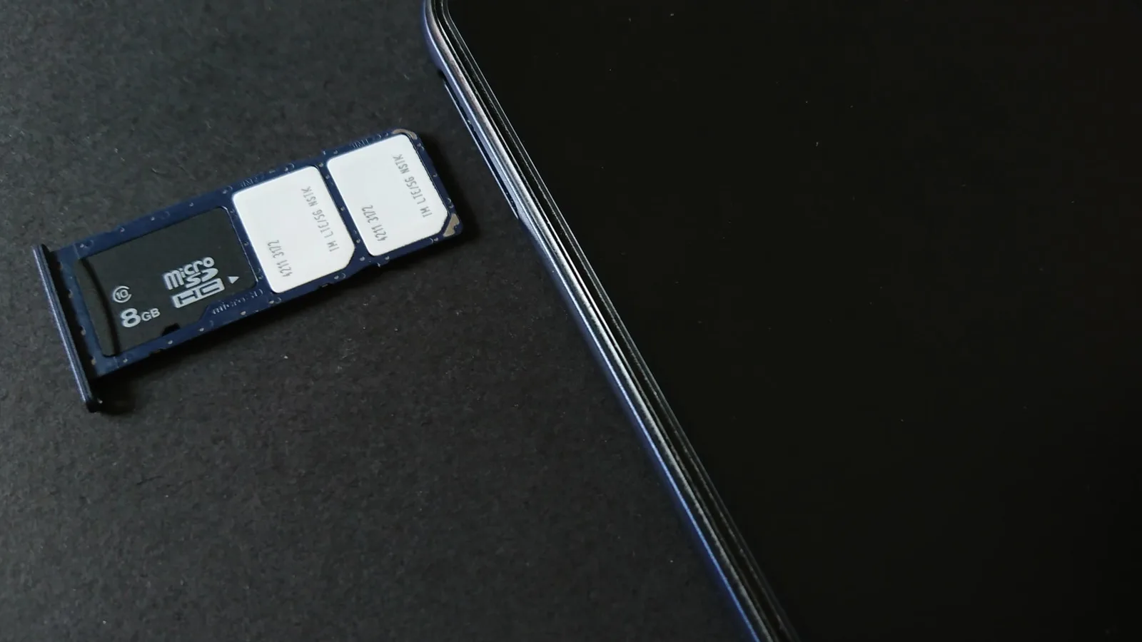 Gaveta com dois chips físicos ao lado de um smartphone: o eSIM dispensa esse chip de plástico