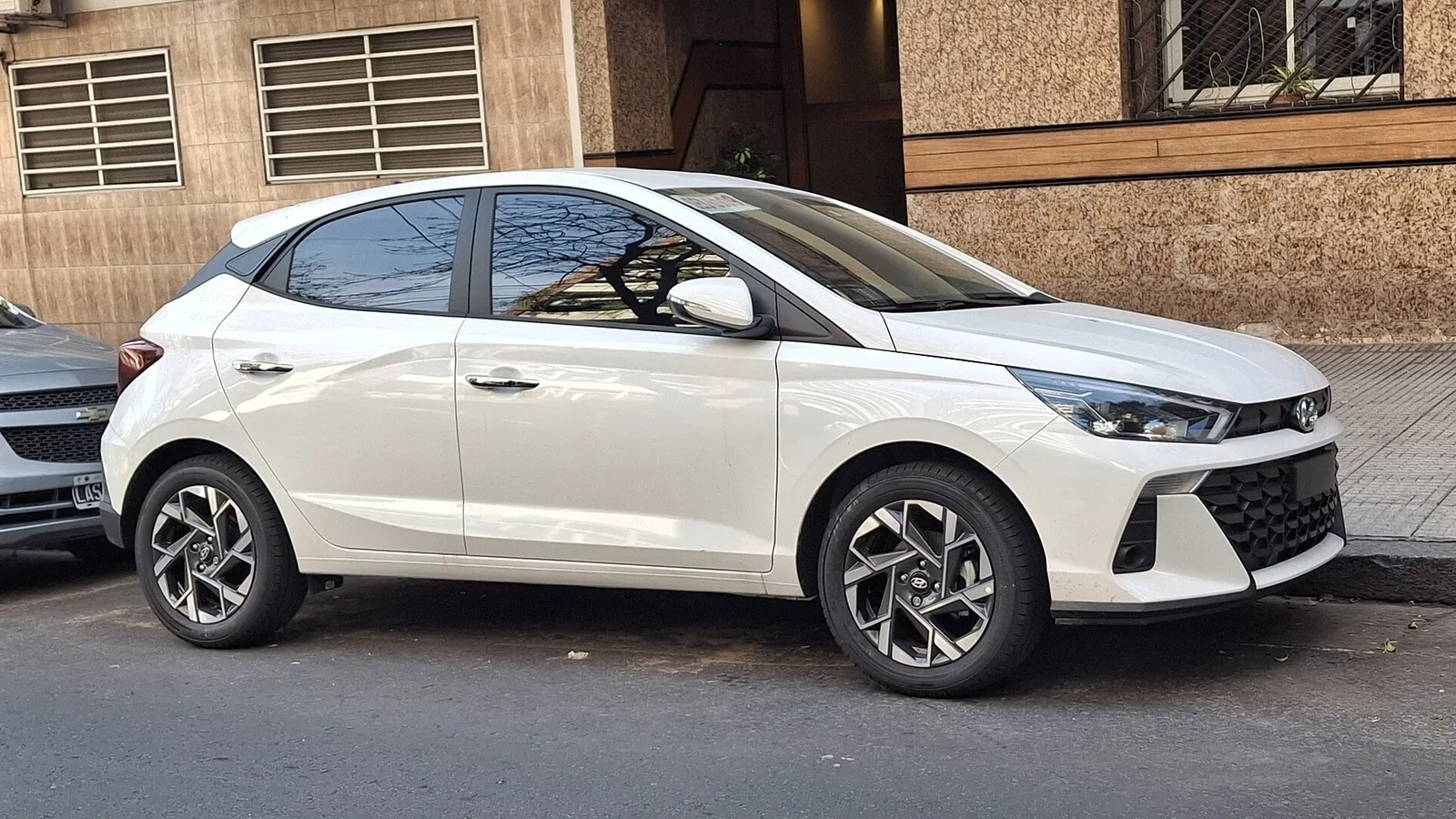 Hyundai HB20 branco visto de frente e de lado, estacionado na rua