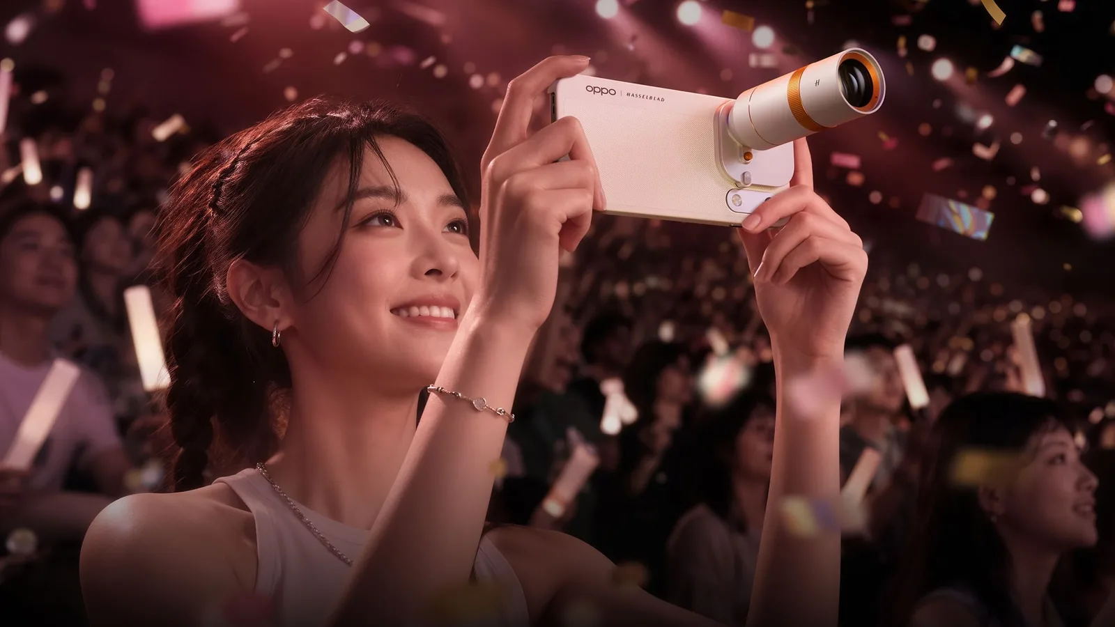 Mulher em um show fotografando com o OPPO Find X10 Pro Max equipado com uma lente extra encaixada na câmera