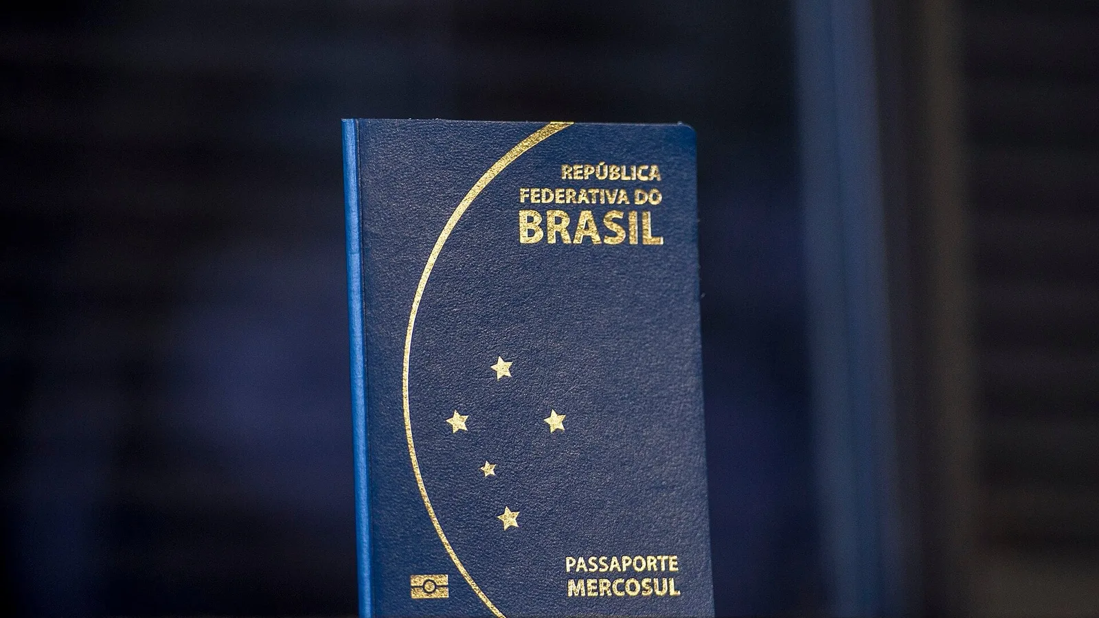 Passaporte brasileiro azul, modelo Mercosul, em pé com a capa fechada