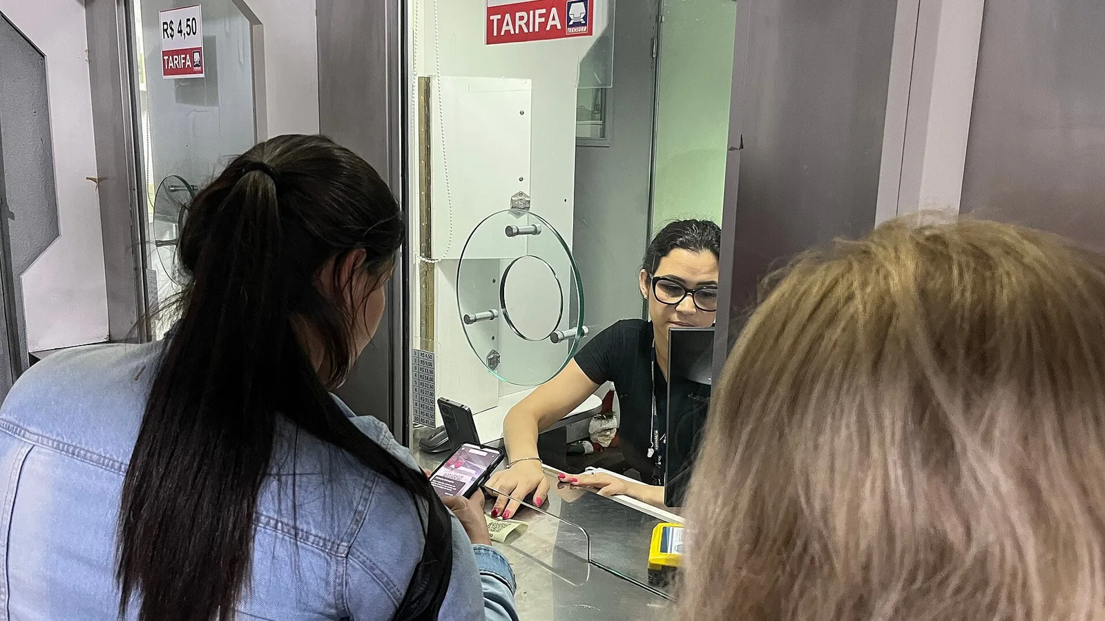 Passageira paga com Pix pelo celular no guichê da bilheteria da Trensurb, em Porto Alegre