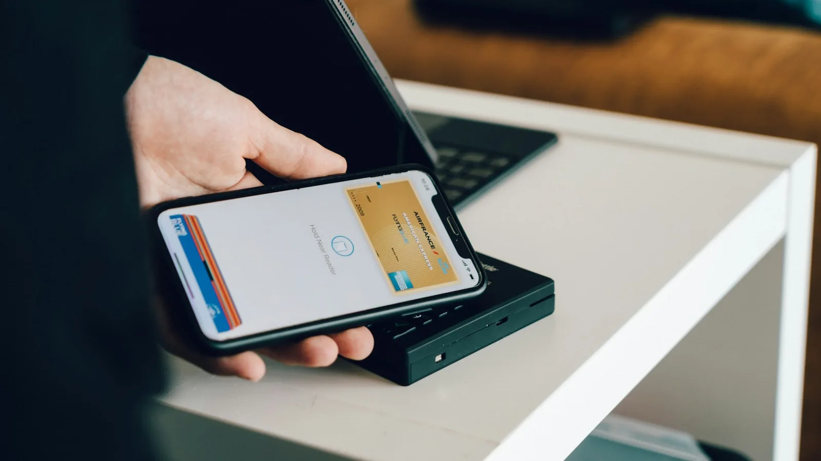 Pessoa paga uma compra aproximando o celular de uma maquininha