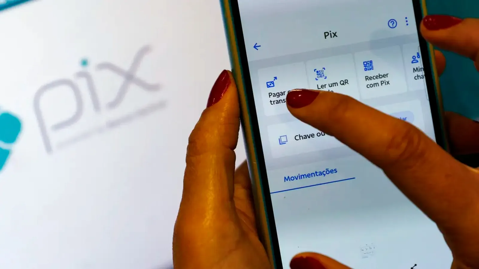 Mão segurando um celular com a tela do Pix em um aplicativo de banco