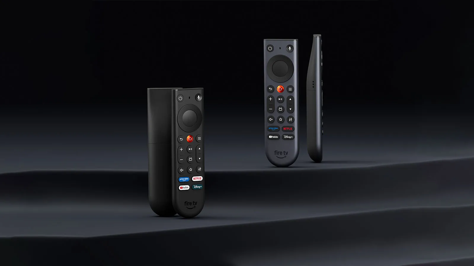 Dois novos controles remotos Fire TV em fundo escuro, um preto e outro em cinza metálico